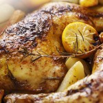 closeup of roast chicken and oven potatoes